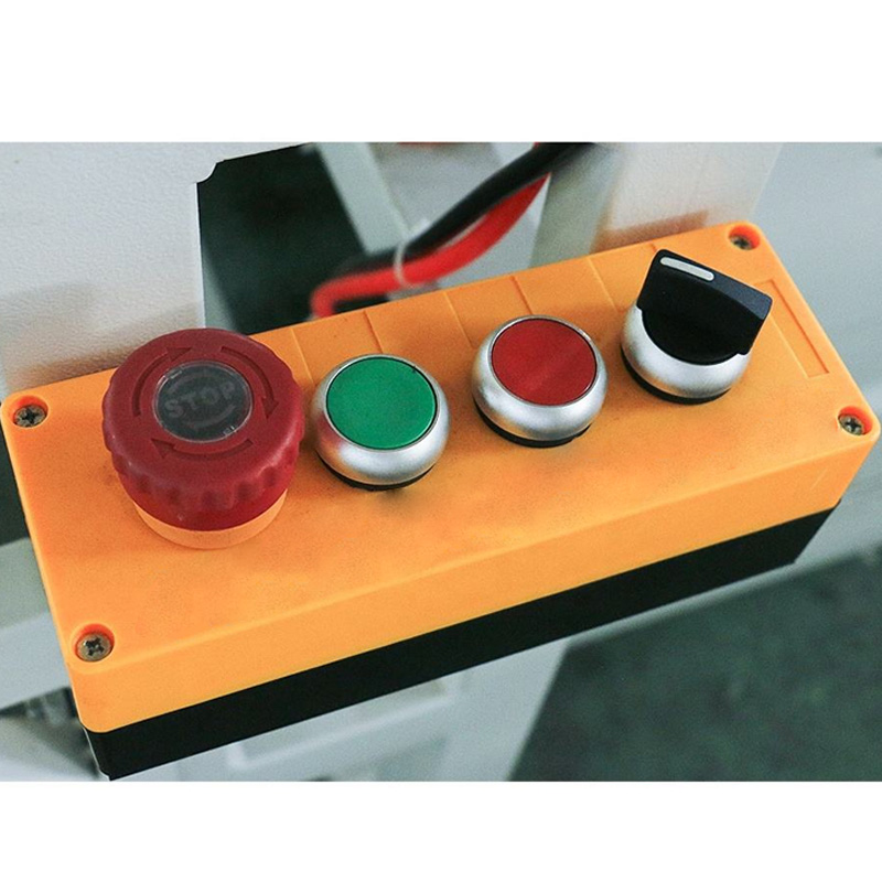 Primo piano del pulsante di arresto di emergenza e dei meccanismi di sicurezza chiaramente contrassegnati.