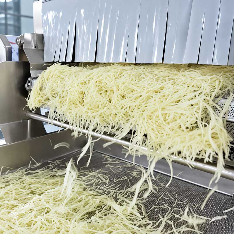 Processed vegetables discharged from continuous industrial blanching equipment